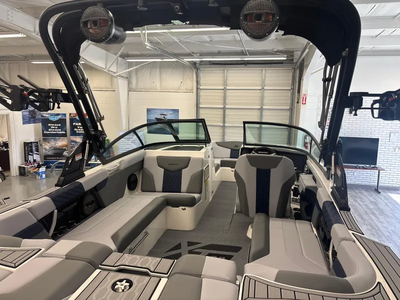 Slide: The Image of 2025 MasterCraft XT22 boat interior with modern seating and sleek design in a showroom. - 8