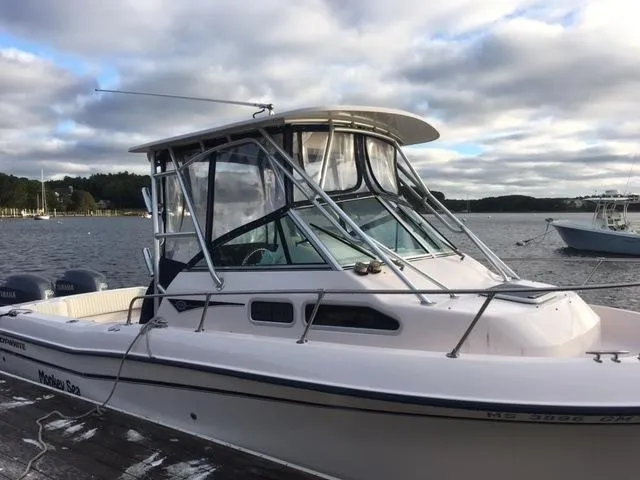 Slide: The Image of 2004 Grady-White 232 Gulfstream boat docked by a scenic lake. - 2