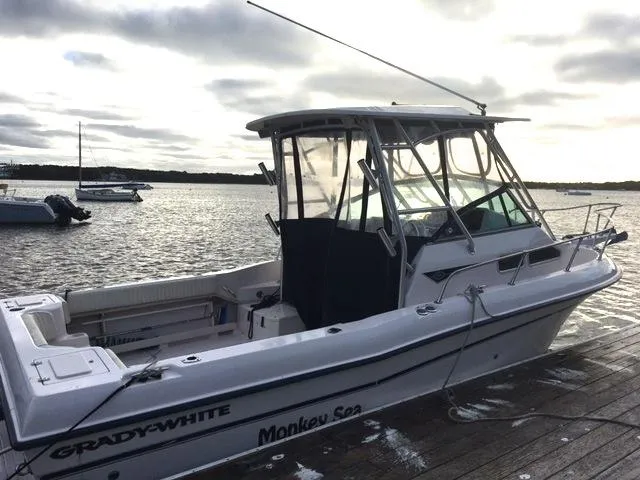 Slide: The Image of 2004 Grady-White 232 Gulfstream boat docked by the water on a cloudy day. - 3