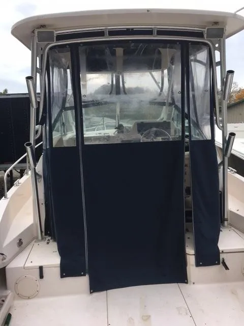 Slide: The Image of 2004 Grady-White 232 Gulfstream boat with blue canvas enclosure. - 5