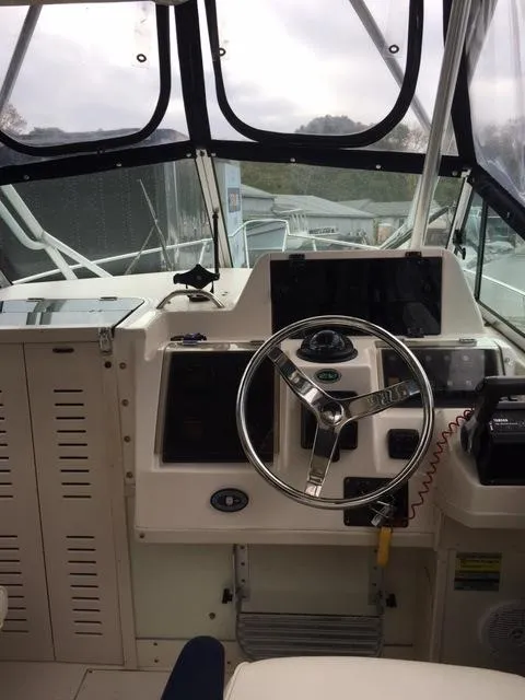 Slide: The Image of 2004 Grady-White 232 Gulfstream boat cockpit with steering wheel and navigation equipment. - 6