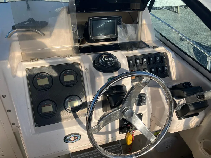Slide: The Image of 2004 Grady-White 232 Gulfstream boat dashboard with steering wheel and navigation instruments. - 7