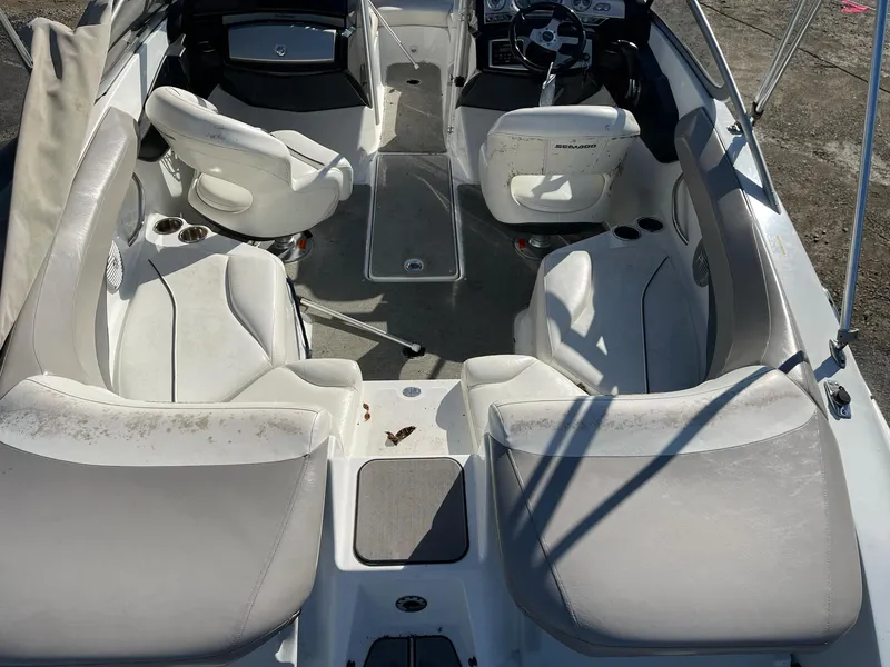 Slide: The Image of 2010 Sea-Doo 210 Challenger boat interior with white seating and steering console. - 13