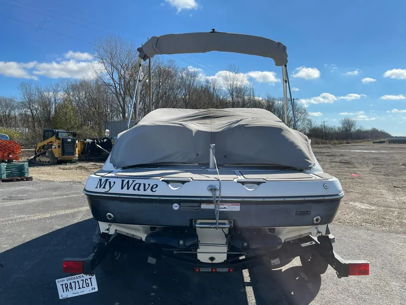 Slide: The Image of 2010 Sea-Doo 210 Challenger boat with cover, parked outdoors. - 2