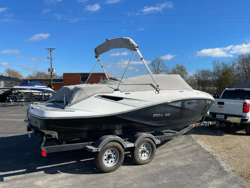 Slide: The Image of 2010 Sea-Doo 210 Challenger boat on trailer with cover, parked outdoors. - 4