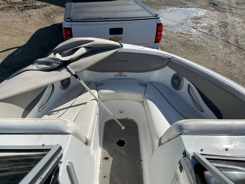 Slide: The Image of 2010 Sea-Doo 210 Challenger boat interior with seating and cover, parked near a white truck. - 6