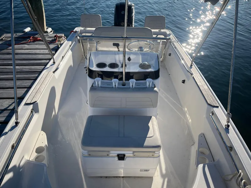 Slide: The Image of 2020 Boston Whaler 170 Montauk boat interior, docked on calm water. - 10