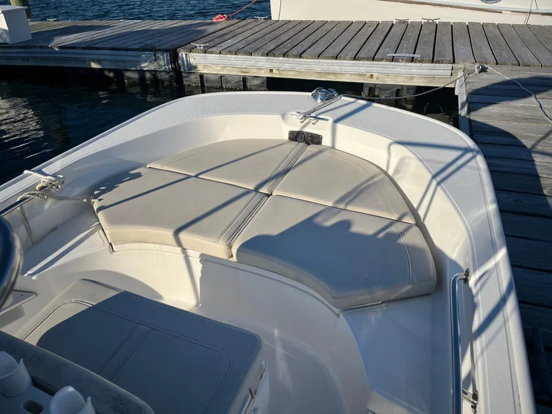 Slide: The Image of 2020 Boston Whaler 170 Montauk boat interior with cushioned seating at dock. - 4