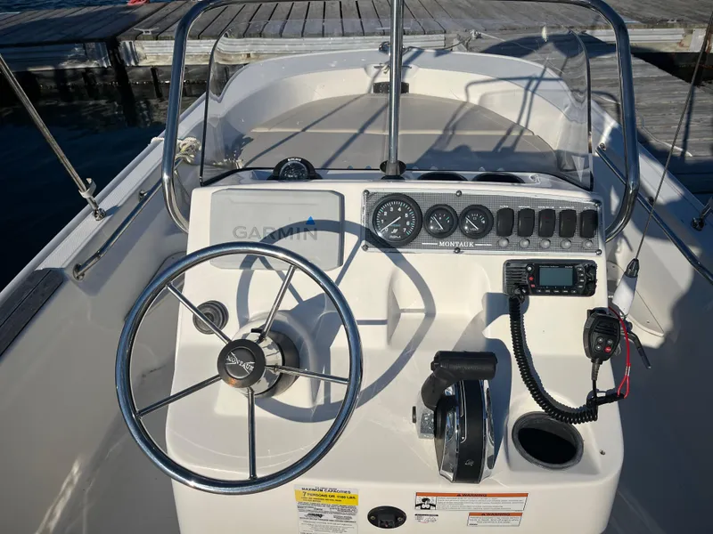 Slide: The Image of 2020 Boston Whaler 170 Montauk boat dashboard with steering wheel and navigation instruments. - 6