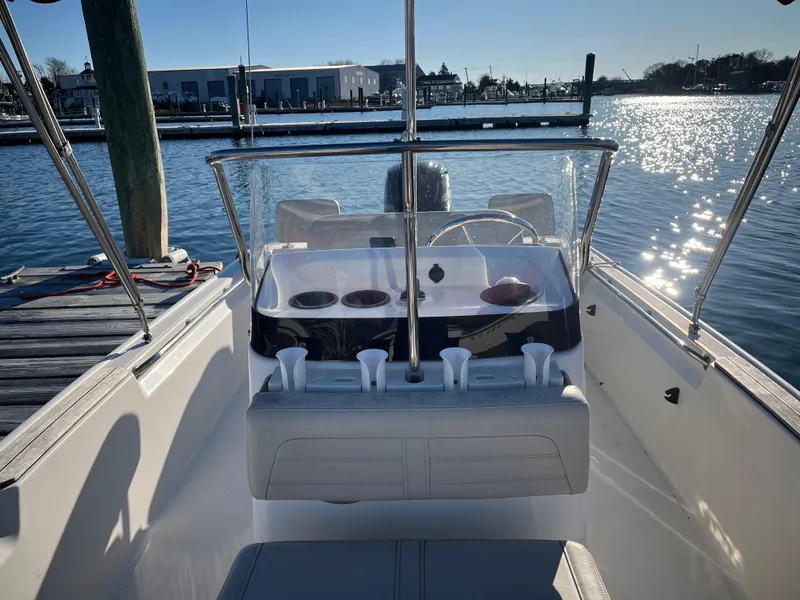 Slide: The Image of 2020 Boston Whaler 170 Montauk boat interior with steering console, docked by the water. - 8