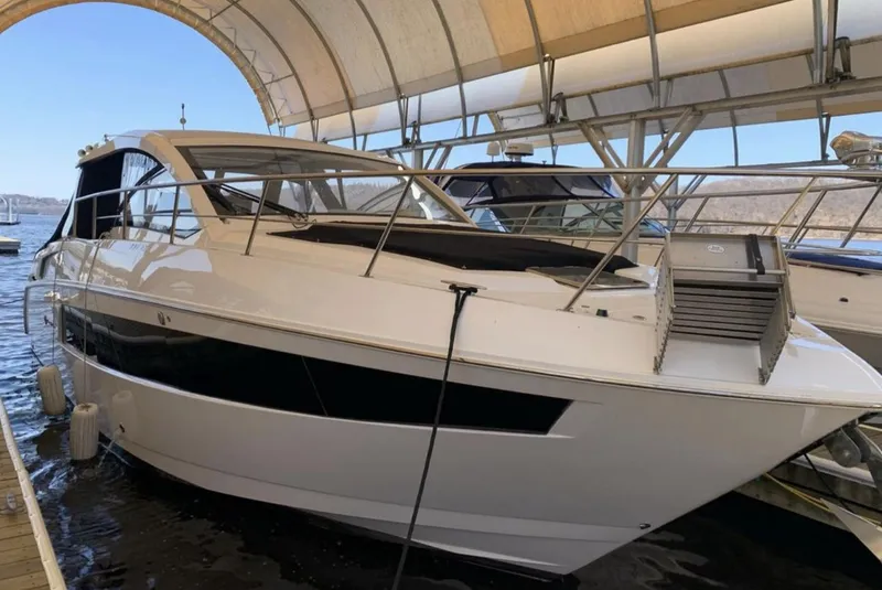 Slide: The Image of 2018 Cruisers 390 Express Coupe docked under a canopy. - 2