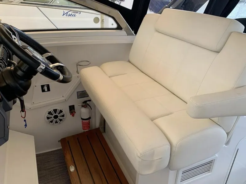 Slide: The Image of 2018 Cruisers 390 Express Coupe interior with white seating and steering wheel. - 8