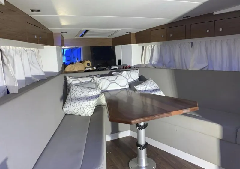 Slide: The Image of Interior of 2018 Cruisers 390 Express Coupe with modern seating and wooden table. - 18