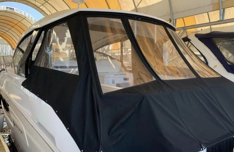 Slide: The Image of 2018 Cruisers 390 Express Coupe with black canvas cover in marina. - 3