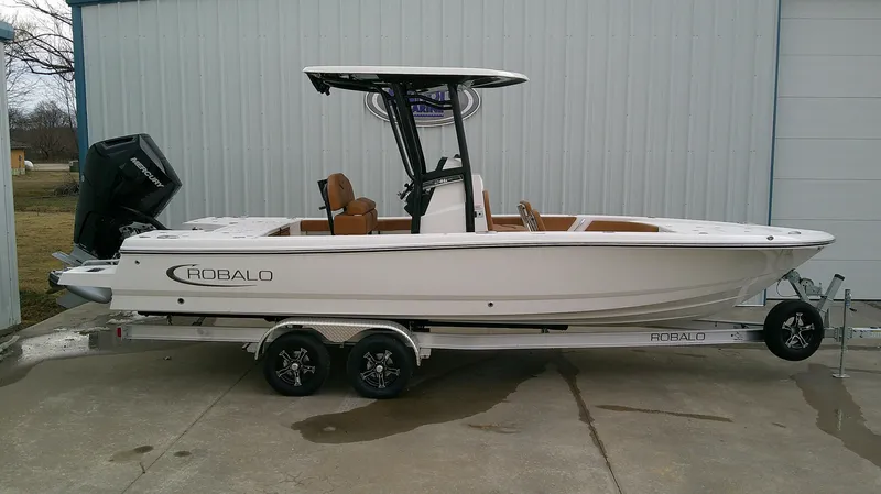Slide: The Image of 2025 Robalo 246 Cayman boat on trailer, parked outdoors. - 0