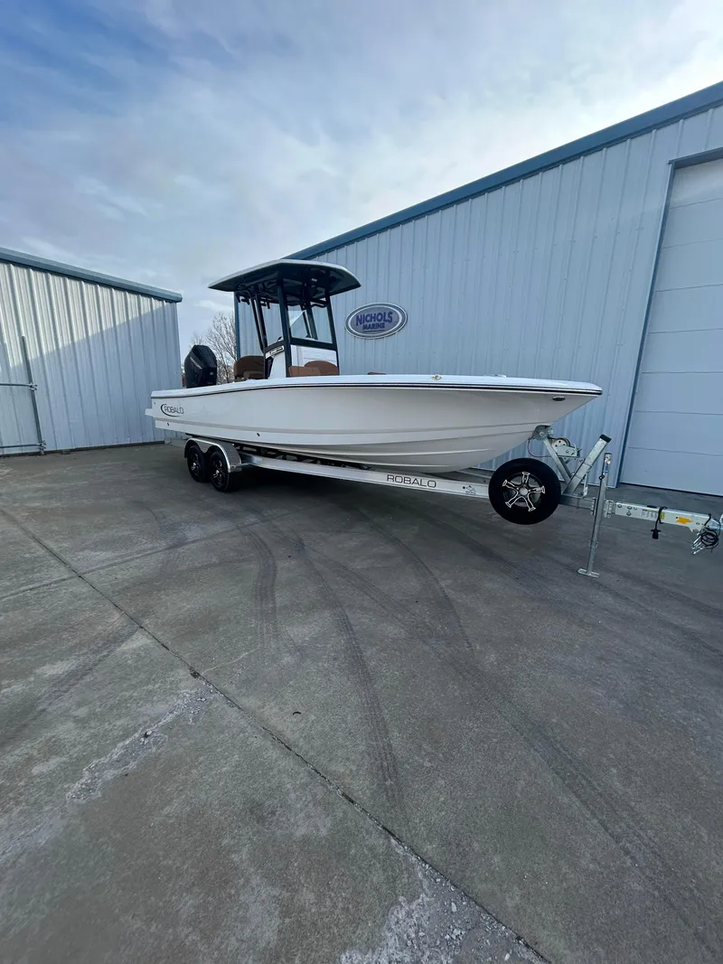 Slide: The Image of 2025 Robalo 246 Cayman boat on trailer outside storage facility. - 1