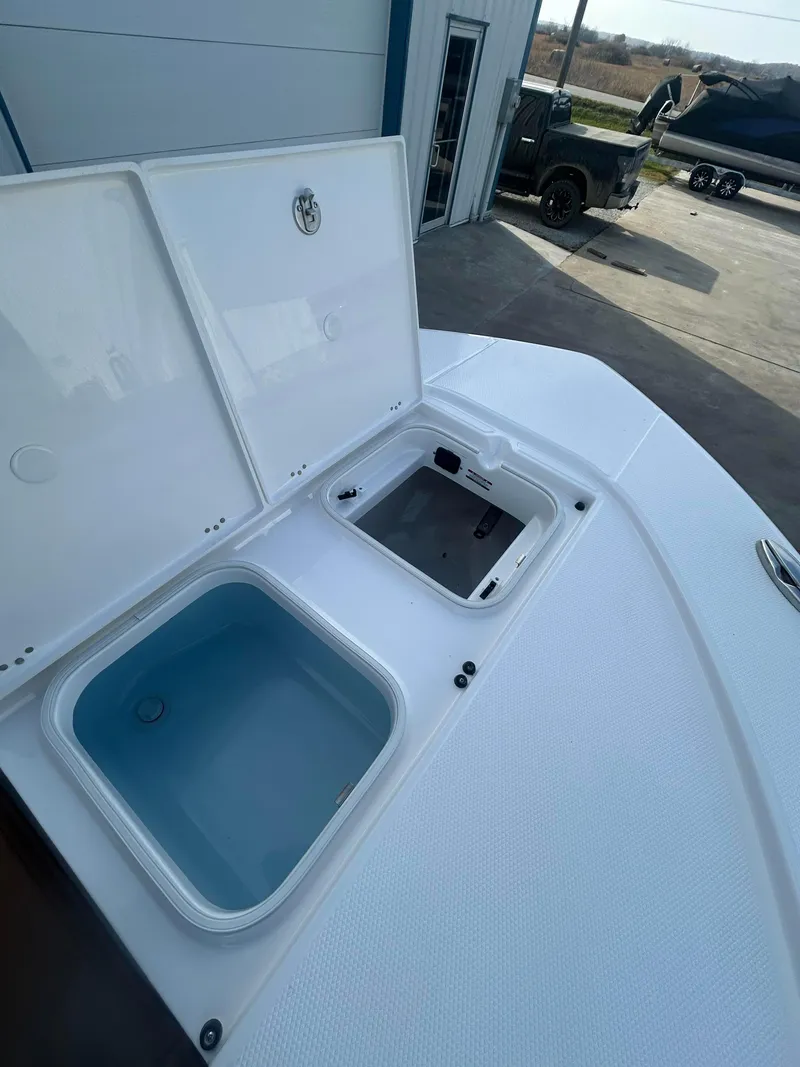 Slide: The Image of 2025 Robalo 246 Cayman boat with open storage compartments on deck. - 11