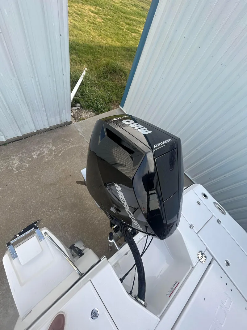 Slide: The Image of 2025 Robalo 246 Cayman boat with Yamaha outboard motor, docked near a metal building. - 4