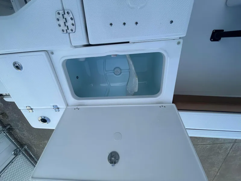 Slide: The Image of 2025 Robalo 246 Cayman boat storage compartment with open lid. - 5