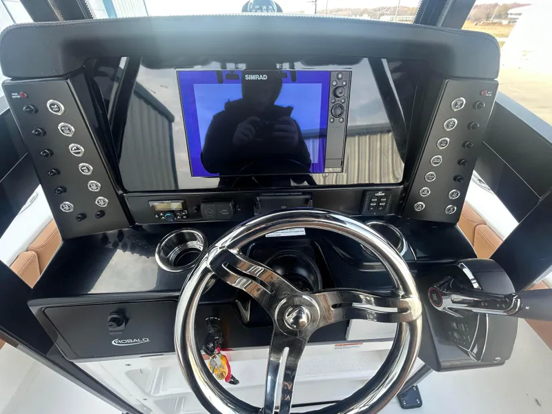 Slide: The Image of 2025 Robalo 246 Cayman boat dashboard with steering wheel and navigation display. - 8