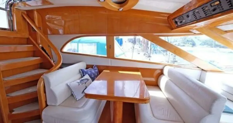 Slide: The Image of 2004 McKinna Pilothouse interior with wooden finishes, dining area, and curved staircase. - 15