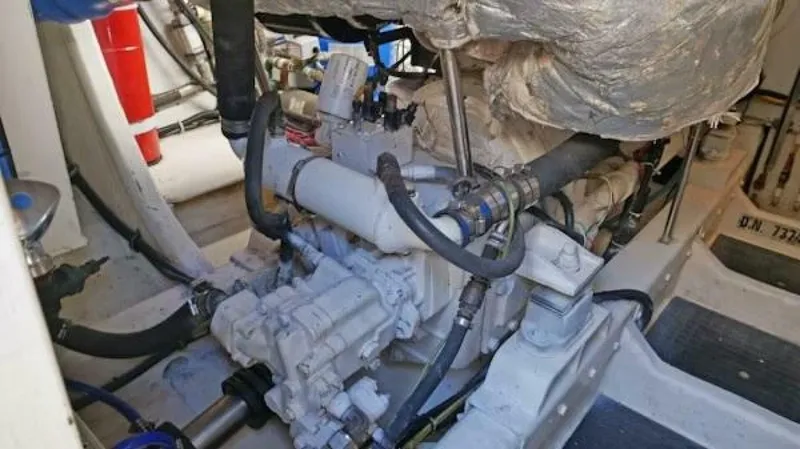 Slide: The Image of Engine room of a 2004 McKinna Pilothouse yacht, showcasing mechanical components and piping. - 33