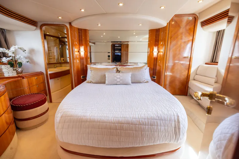 Slide: The Image of Luxurious bedroom interior of 2005 Azimut 68 yacht with elegant wood finishes and plush bedding. - 24
