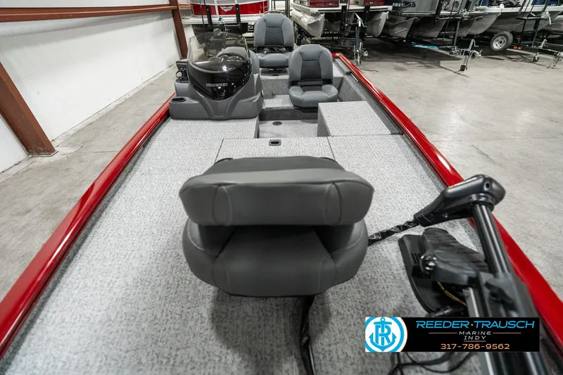 Slide: The Image of 2023 Tracker Pro 170 boat interior with gray seating and red trim in showroom. - 13