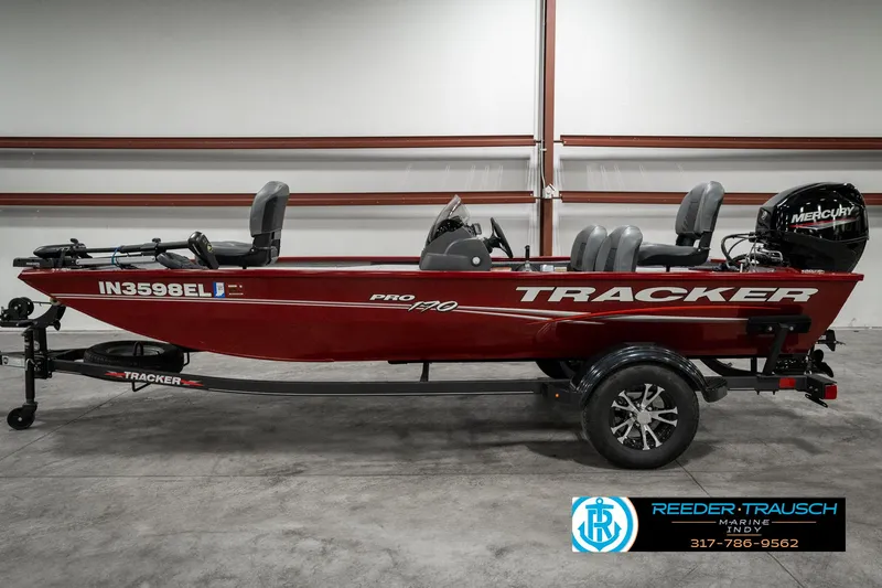 Slide: The Image of 2023 Tracker Pro 170 boat in red, side view, displayed indoors. - 3