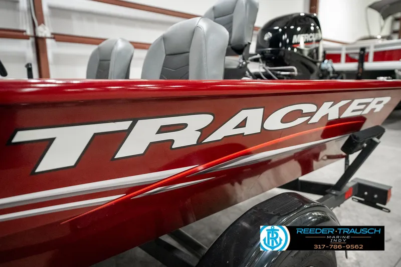 Slide: The Image of 2023 Tracker Pro 170 boat with red exterior and gray seats in showroom. - 42