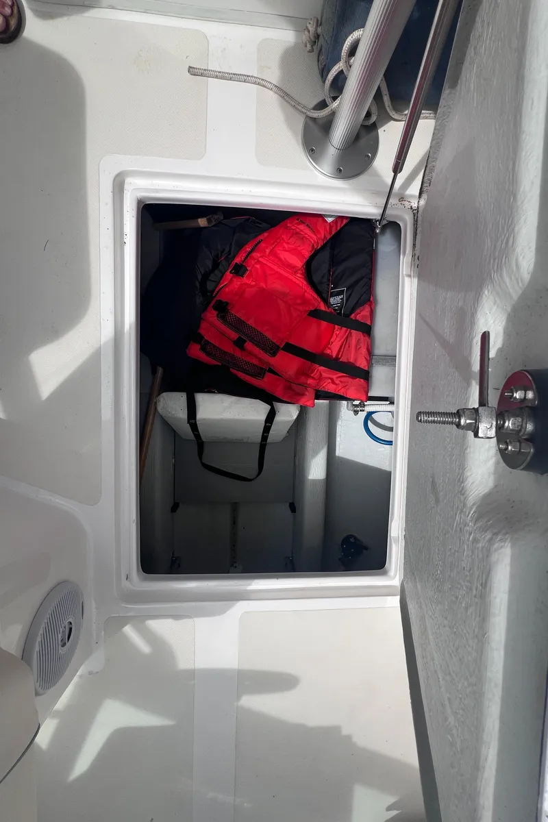 Slide: The Image of 2011 Hunt Yachts Harrier 25 storage compartment with red life jacket. - 10