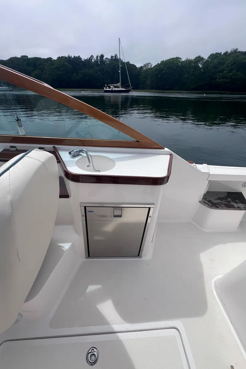 Slide: The Image of 2011 Hunt Yachts Harrier 25 interior with sink, fridge, and scenic water view. - 11