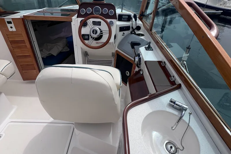 Slide: The Image of Interior of 2011 Hunt Yachts Harrier 25, featuring helm, seating, and sink. - 14