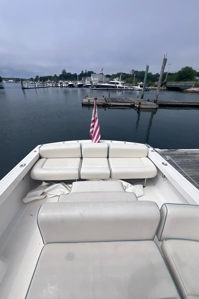 Slide: The Image of 2011 Hunt Yachts Harrier 25 with white seating, docked in a marina. - 19