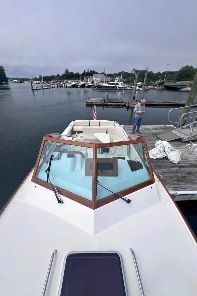 Slide: The Image of 2011 Hunt Yachts Harrier 25 docked at a marina, featuring sleek design and spacious deck. - 2