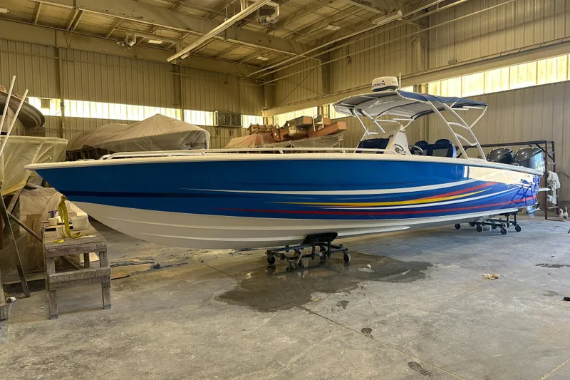 The Image of 2014 Concept 36 boat with vibrant stripes in a warehouse setting. - 0