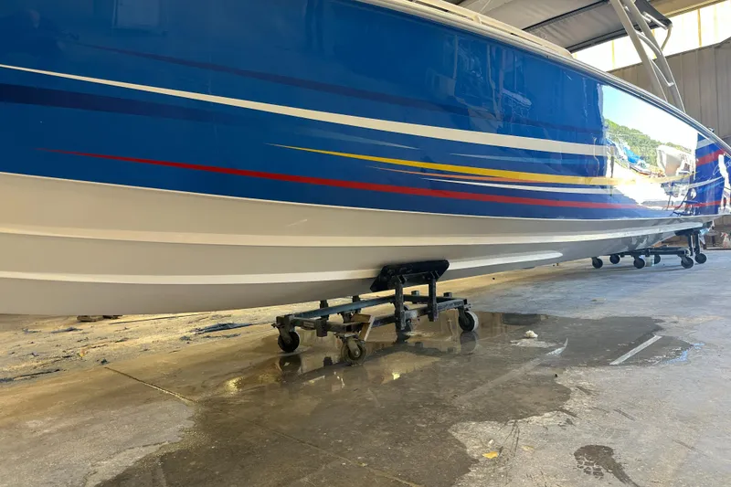 Slide: The Image of Blue and white Concept 36 boat from 2014 on a wheeled stand in a garage. - 2