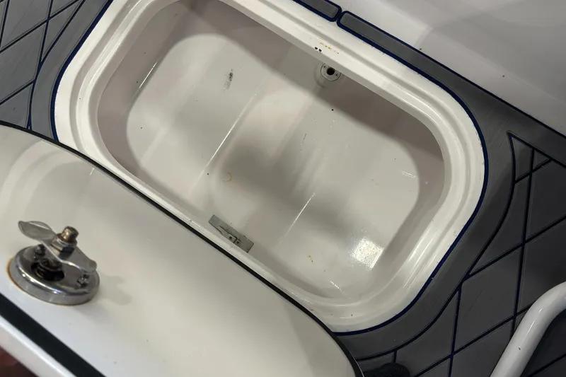 Slide: The Image of Open storage compartment on a 2014 Concept 36 boat, featuring a secure latch. - 32