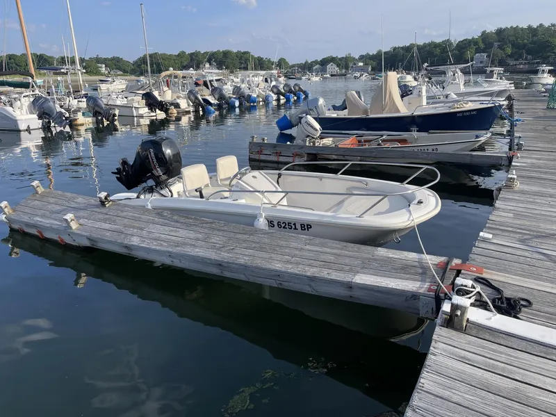 Slide: The Image of 2022 Boston Whaler 130 Super Sport docked at a marina. - 2