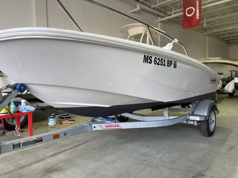 Slide: The Image of 2022 Boston Whaler 130 Super Sport boat on trailer in garage. - 4