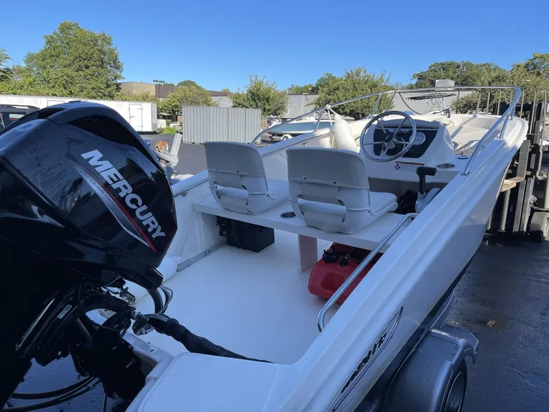 Slide: The Image of 2022 Boston Whaler 130 Super Sport boat with Mercury engine, parked outdoors. - 5