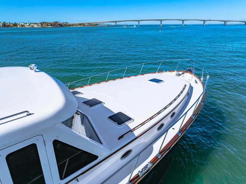 Slide: The Image of 2024 Vicem 62 Classic yacht cruising on clear blue waters near a bridge. - 22