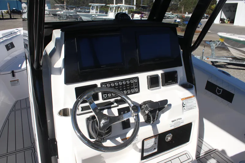 Slide: The Image of 2025 Sea Fox 288 Commander boat dashboard with steering wheel and control panels. - 12