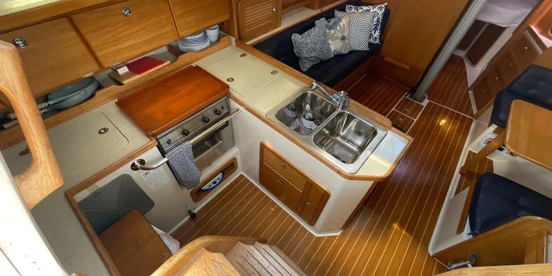 Slide: The Image of Interior of 2005 Catalina 350 MkII sailboat with kitchen and seating area. - 16