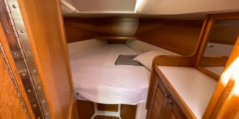 Slide: The Image of 2005 Catalina 350 MkII cabin interior with cozy bed and wooden cabinetry. - 22