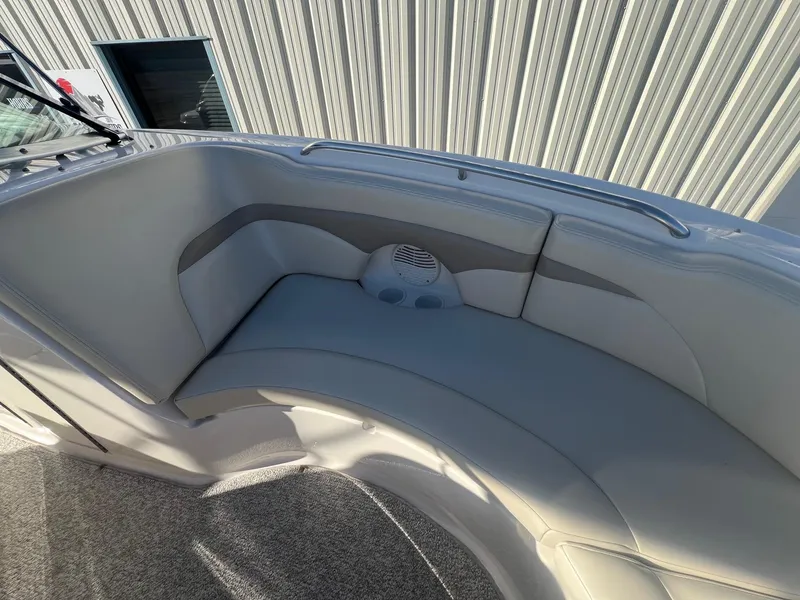 Slide: The Image of 2002 Chaparral Sunesta 243 boat interior with cushioned seating and cup holders. - 13
