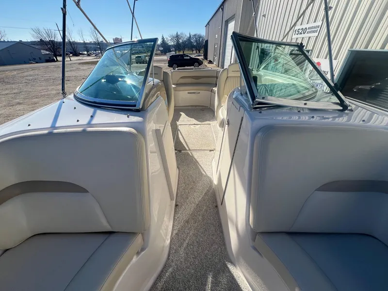 Slide: The Image of 2002 Chaparral Sunesta 243 boat interior with seating and windshield, parked outdoors. - 14