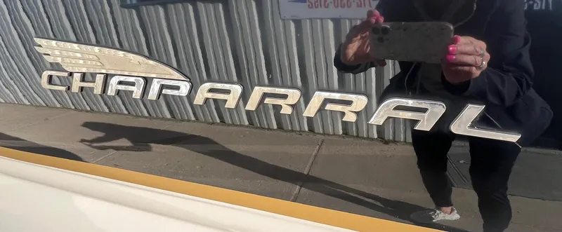 Slide: The Image of Chaparral Sunesta 243 boat logo, 2002 model, reflective surface with person taking photo. - 3