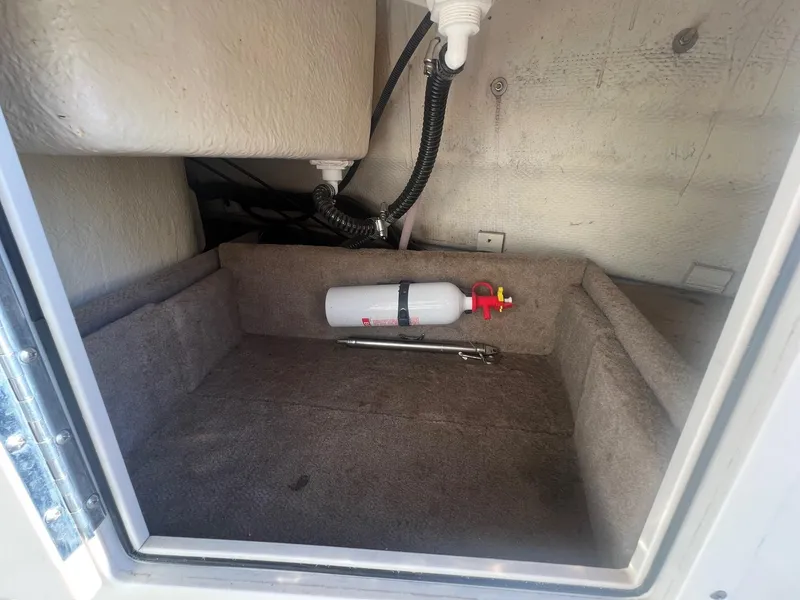 Slide: The Image of Storage compartment in 2002 Chaparral Sunesta 243 boat with fire extinguisher. - 34