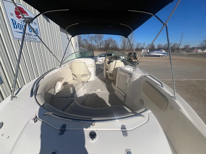Slide: The Image of 2002 Chaparral Sunesta 243 boat interior with seating and canopy, parked outdoors. - 9